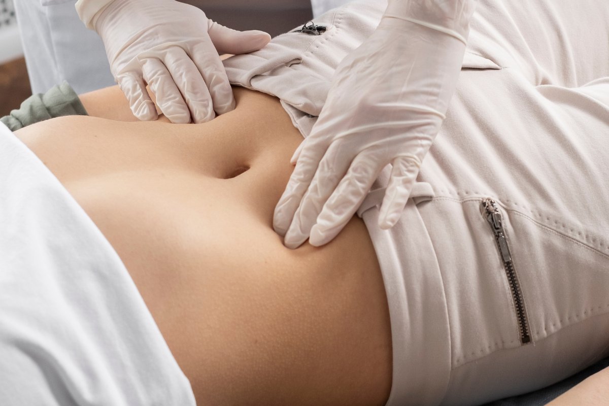 A clinician carrying out a respectful abdominal examination during consultation